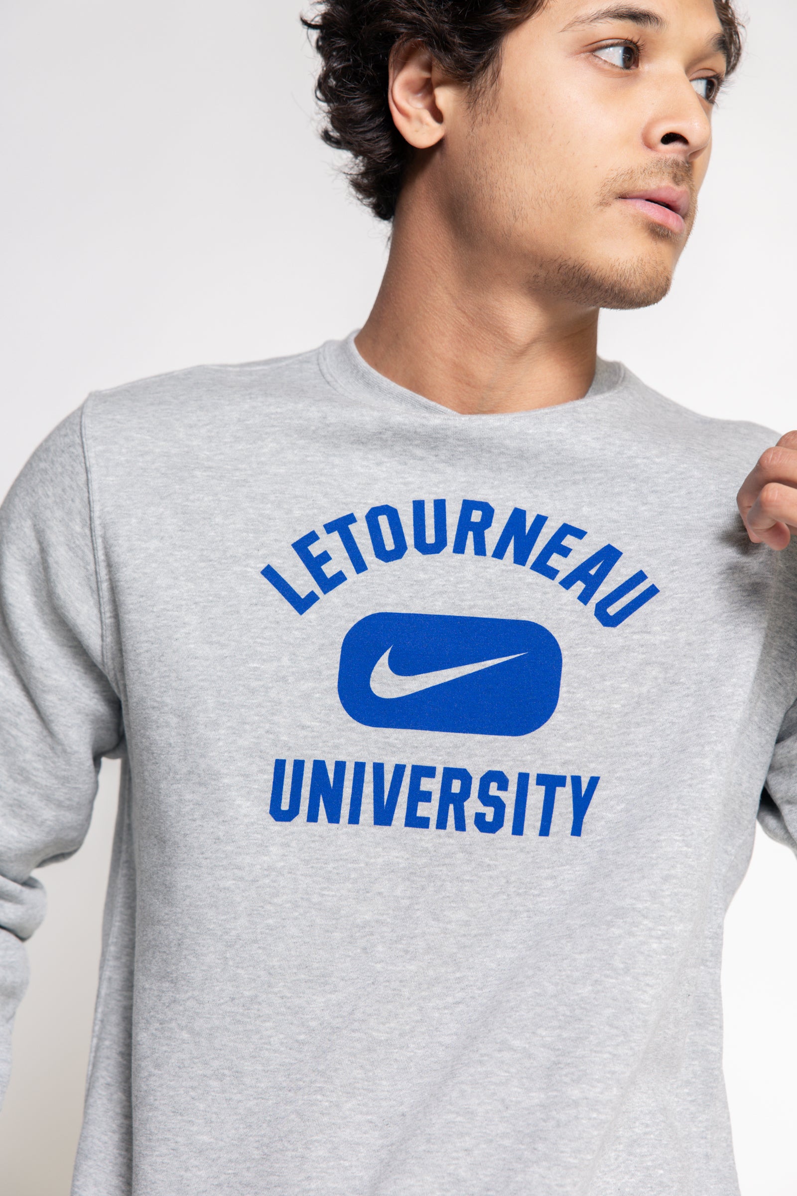 Person wearing a gray Nike sweatshirt with 'Letourneau University' printed on it.