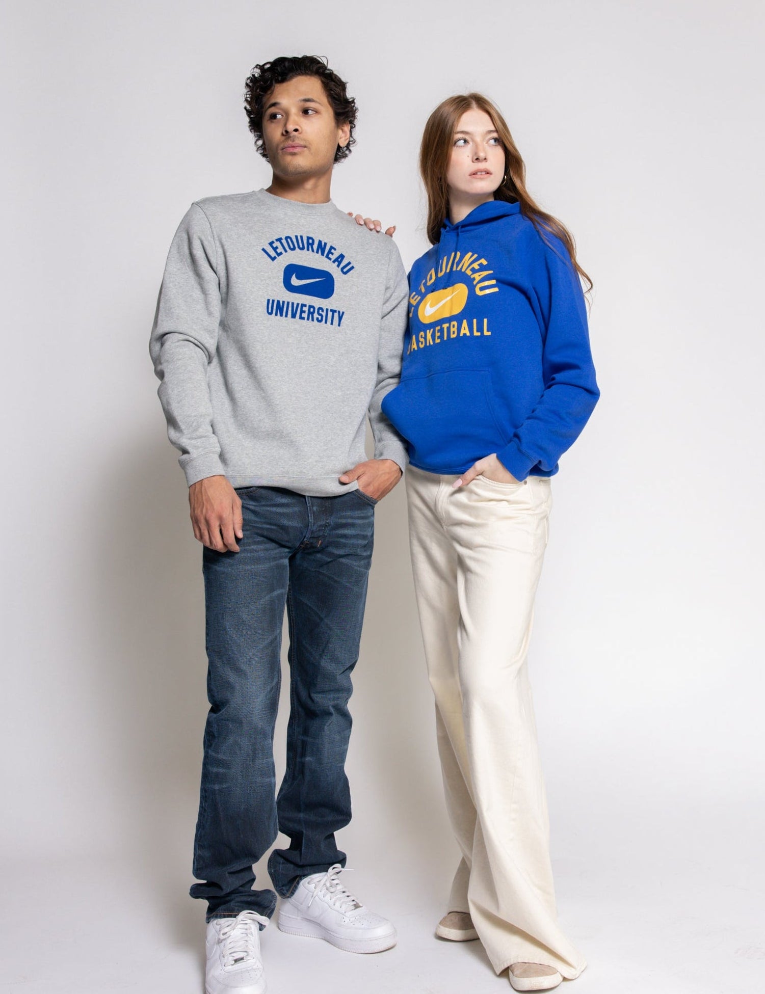 Two people wearing Letourneau sweatshirts with Nike branding on a plain background