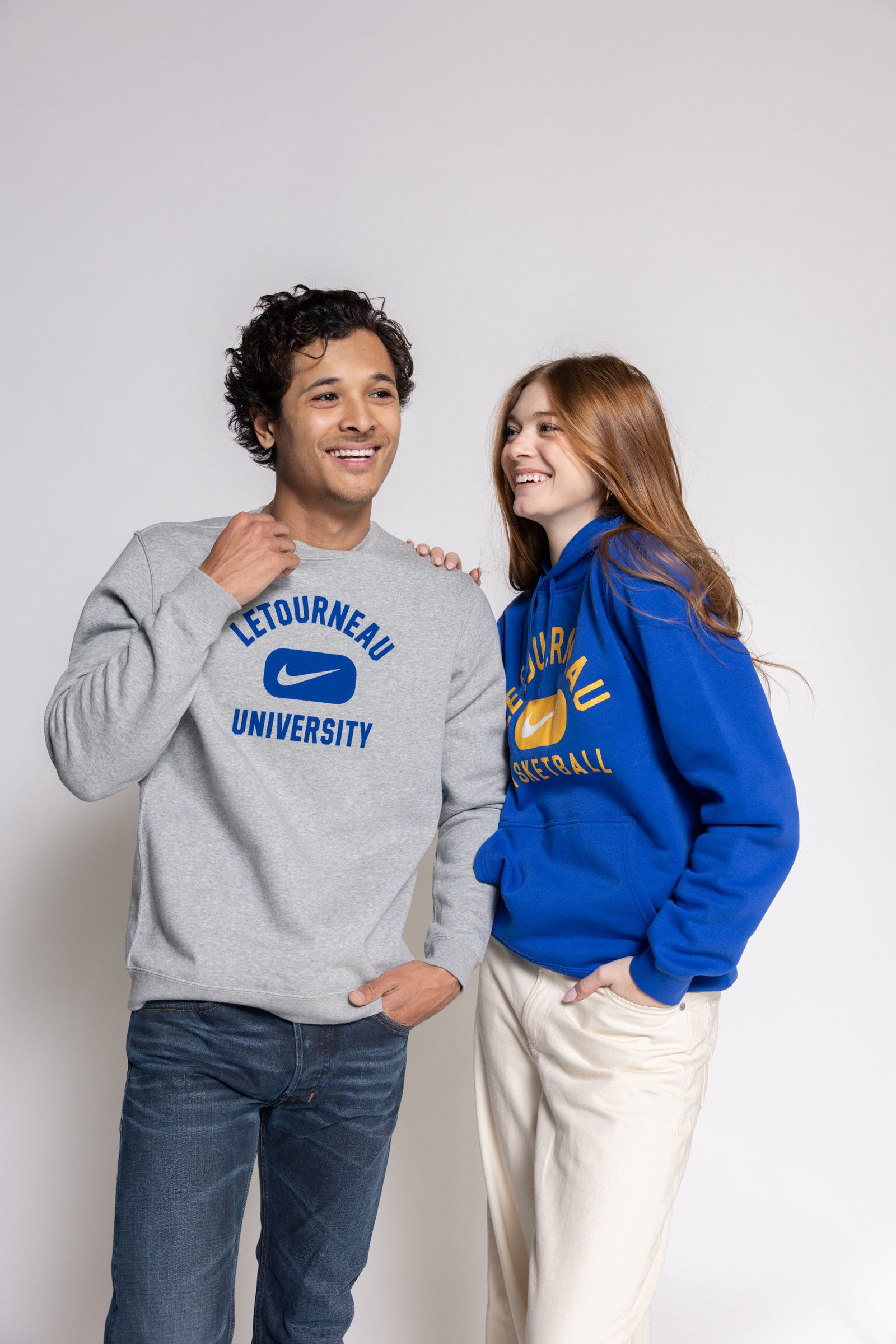 Two people wearing Nike Letourneau University sweatshirts against a white background