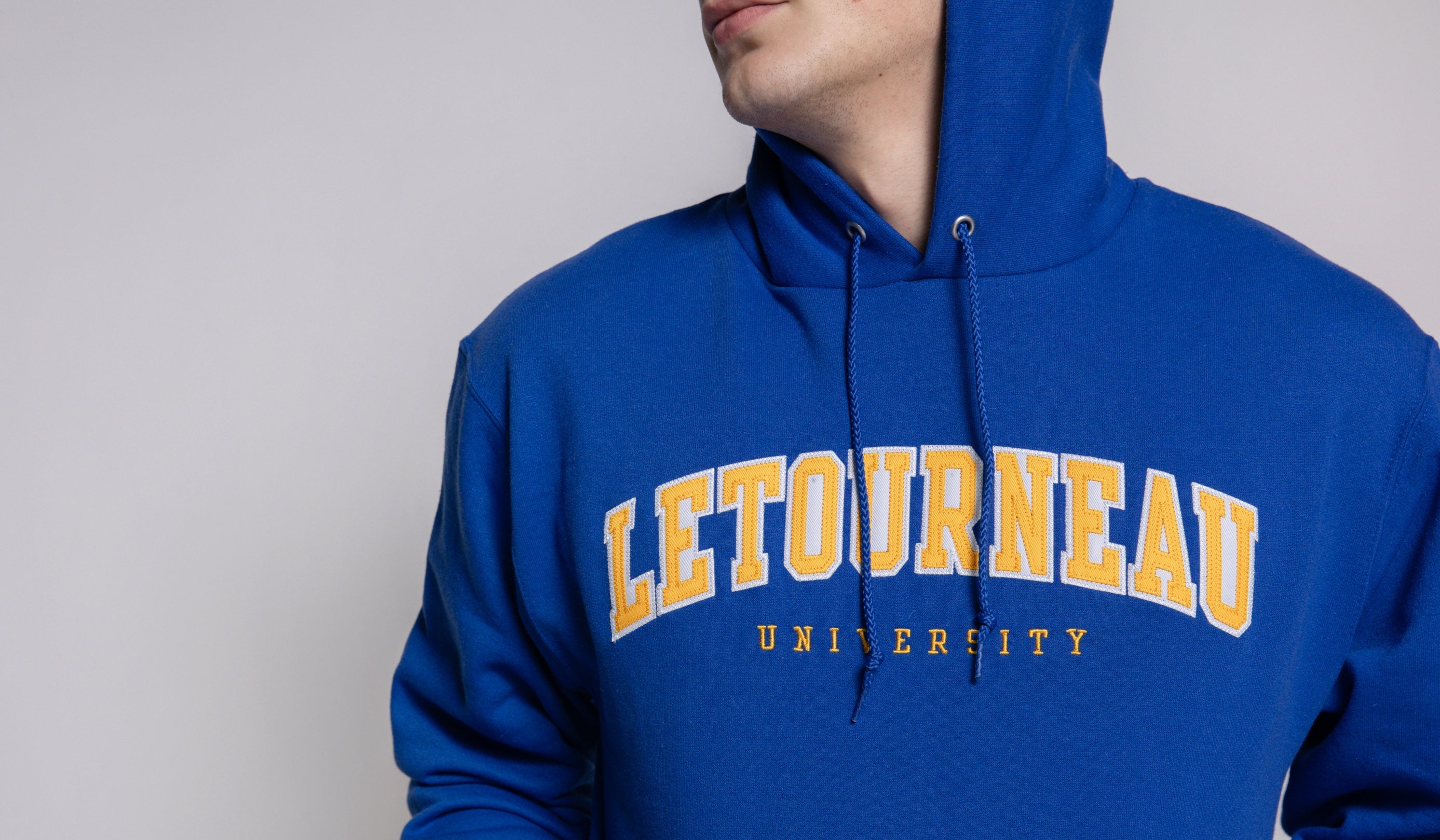 Person wearing a blue hoodie with 'Letourneau University' printed on it against a plain background